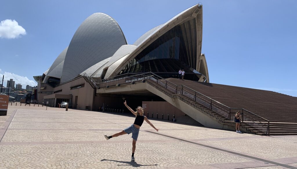 Chica posando delante de la Ópera de Sidney en Australia